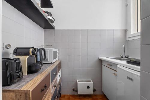 une cuisine avec un comptoir avec un micro-ondes dans l'établissement Studio Malaussena - Welkeys, à Nice