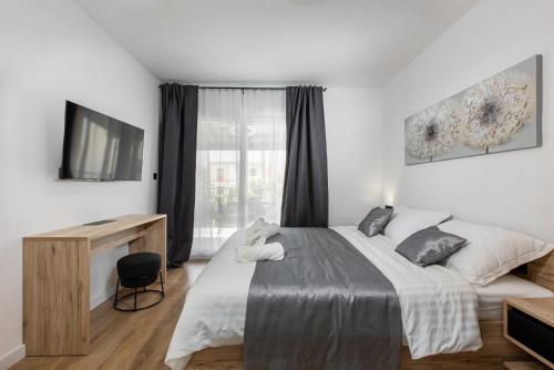 ein Schlafzimmer mit einem Bett, einem Schreibtisch und einem Fernseher in der Unterkunft Villa Luce in Podstrana