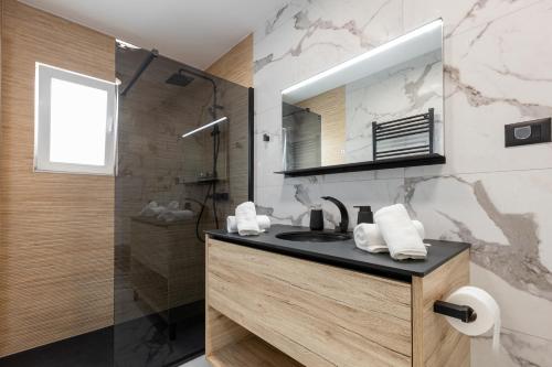 ein Badezimmer mit Waschbecken und Dusche mit Spiegel in der Unterkunft Villa Luce in Podstrana