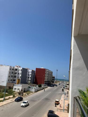 a view of a city street with cars on the road at Appartement lumineux près de la plage de Sidi Bouzid in El Jadida