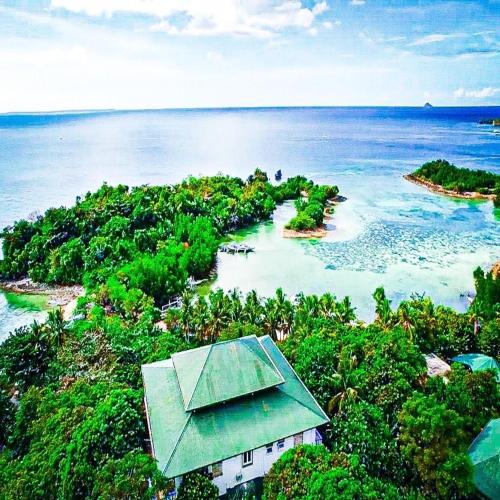 an island with a house in the middle of the ocean at ZHANG RESORT and DIVE CENTER in Daanbantayan