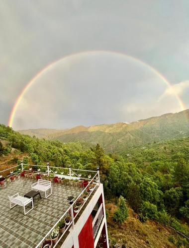 a rainbow in the sky with at EcoEscape Mukteshwar in Mukteswar