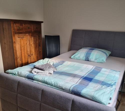 a bed with a blue comforter and a pillow at Ferienwohnung Aura in Bornhöved