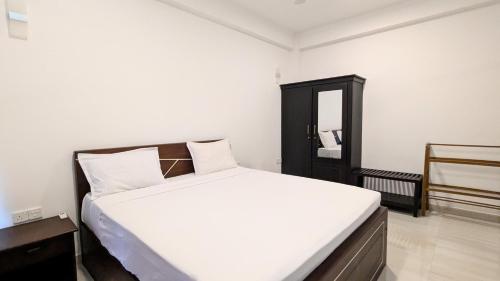 a bedroom with a white bed and a mirror at Dutch Villa - Trincomalee in Trincomalee