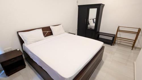 a bedroom with a bed and a mirror and a chair at Dutch Villa - Trincomalee in Trincomalee