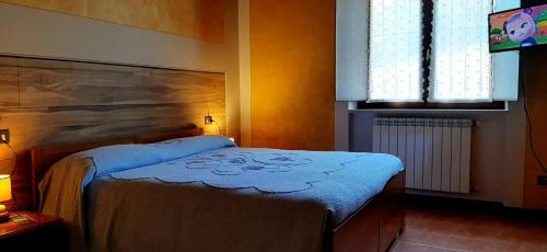 a bedroom with a bed with a blue blanket at Agriturismo dell'Altopiano in Serle