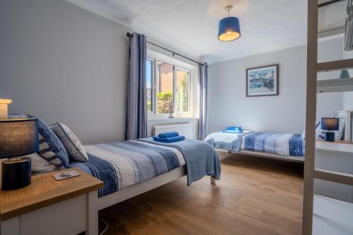 a bedroom with two beds and a window at Cobbles End by Winterton Cottages in Winterton-on-Sea