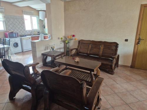 a living room with a table and chairs and a kitchen at Family Beach Apartment Marbella in El Jadida