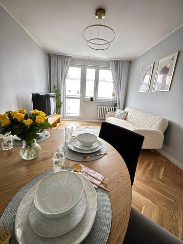 a living room with a table with plates on it at Golden Bay Derdowskiego 2 in Puck