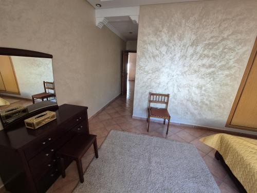a bedroom with a dresser and a mirror and a bed at Family Beach Apartment Marbella in El Jadida