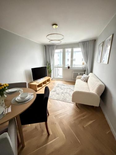 a living room with a table and a couch at Golden Bay Derdowskiego 2 in Puck