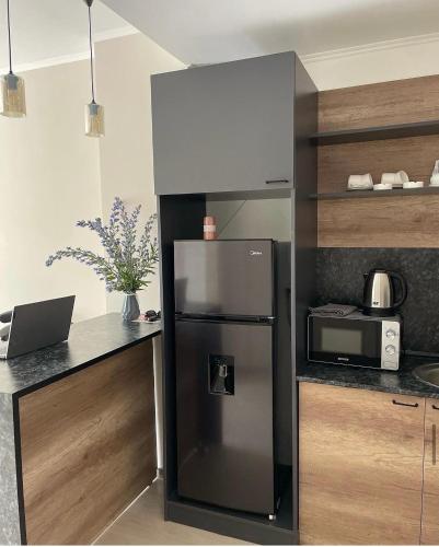 a kitchen with a refrigerator and a microwave at Tsaghkadzor Alvina complex in Tsaghkadzor
