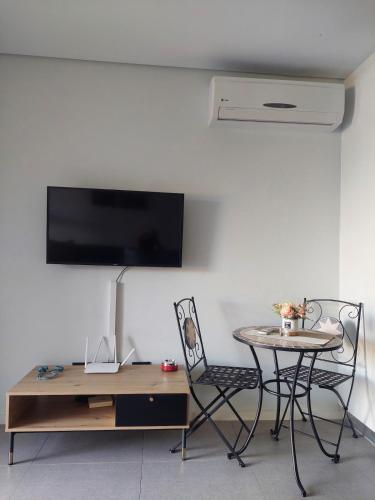 a living room with a table and a table and a table and chair at Cosy, spacious studio apartment in Umhlanga