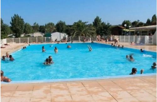 un groupe de personnes nageant dans une piscine dans l'établissement Mobil Home piscine, proche plages, à Fréjus