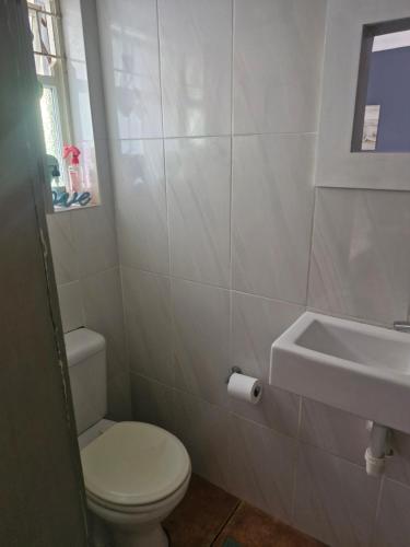 un baño con inodoro y lavabo en Jamieson Hide Away, en Simonʼs Town