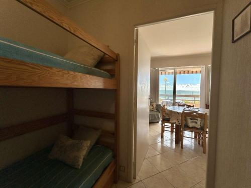 - une chambre avec des lits superposés et une salle à manger avec une table dans l'établissement Studio agréable 4 pers. avec terrasse et parking, La Baule - FR-1-245-133, à La Baule