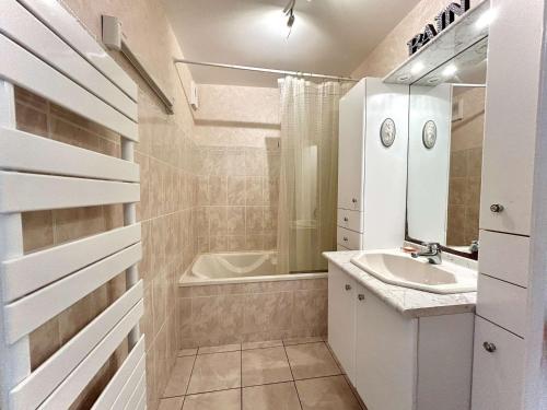 La salle de bains blanche est pourvue d'un lavabo et d'une baignoire. dans l'établissement Appartement T2 traversant face à la mer avec terrasse et garage à Pornichet, proche Casino - FR-1-245-180, à Pornichet