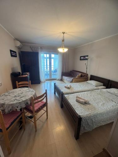 a bedroom with two beds and a table and chairs at Apartman Maslinjak in Krašići