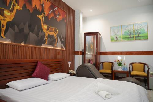 1 dormitorio con 1 cama y una pintura de una jirafa en Khách Sạn Khánh Vy Airport TSN - Cổng Nhà Ga T3, en Ho Chi Minh