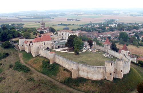 une vue aérienne d'un château sur une colline dans l'établissement les vieilles Halles de Villebois, à Villebois-Lavalette