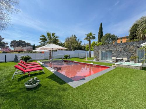 une cour avec une piscine, une table et un parasol dans l'établissement Villa Deluxe Antibes & Private Appartement - Pool - Spa - Cinéma, à Antibes