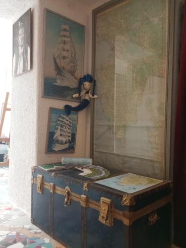 a blue trunk sitting next to a wall with a doll on it at By Artist in Pićan