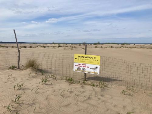 a sign on a fence in the desert at Modern Gdańsk Wyspa Sobieszewska in Gdańsk