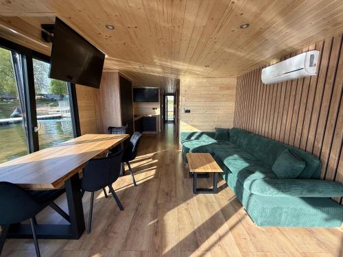 a living room with a green couch and a table at House Boat s výhledem na Wake Port in Brandýs nad Labem-Stará Boleslav