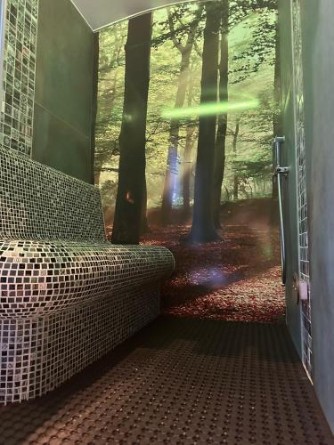 a room with a couch in a forest with trees at Loo Mare - Floating Tiny House All inclusive in Merselo