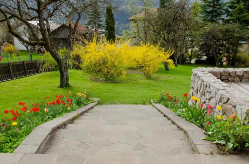 a garden with flowers and a stone walkway at B&B Rossodisera in Domegge di Cadore