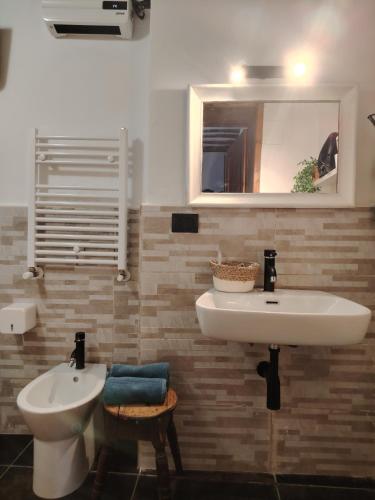 a bathroom with a sink and a toilet and a mirror at Dolce Dimora Siena in Siena