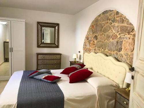 a bedroom with a large bed with red pillows at Ogliastra Luxury Apartment - AJPSARDINIA in Tortolì