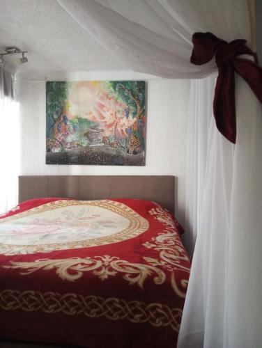 a bedroom with a bed with a red and white comforter at By Artist in Pićan