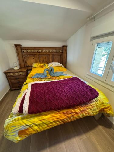 a bedroom with a bed with a colorful comforter at La cabaña de Paredes in Paredes de Buitrago
