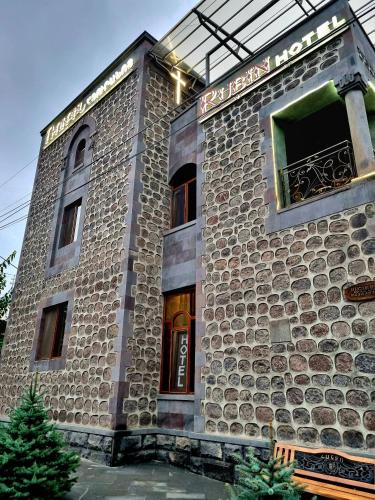 a stone building with a sign on it at Rubin Hotel in Goris