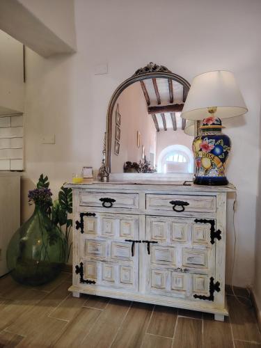 a white dresser with a lamp on top of it at Dolce Dimora Siena in Siena