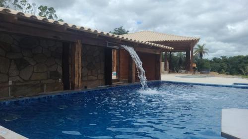 a swimming pool with a water fountain at Pousada Kart Clube in São João del Rei