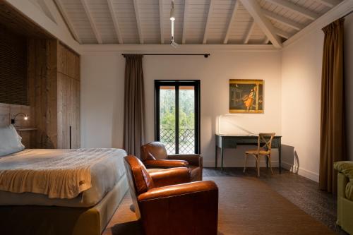 a bedroom with a bed and a desk and a chair at Vinte-Quinta da Boavista in Ponte de Lima