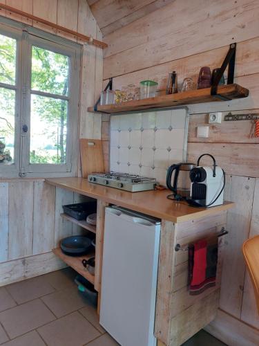 Il comprend une cuisine dotée de murs en bois et d'un réfrigérateur blanc. dans l'établissement Tinyhouse La Jonquille, à Hurecourt