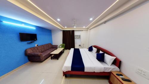 a hotel room with a large bed and a couch at Hotel Eleven Elites in Kota