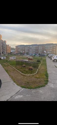 a park with a bench in the middle of a city at Apartamento a pasos de ruta 5 sur in Curicó