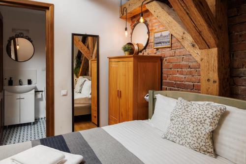 a bedroom with a bed and a brick wall at Wood House Republicii in Braşov