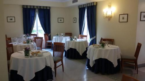 a dining room with two tables with white tablecloths at Hotel Lario in Mezzegra