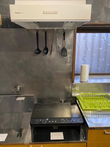 a kitchen with a stove top oven in a kitchen at 貸切民泊 手寄の宿 JR福井駅東口から徒歩5分 5min 安い in Fukui