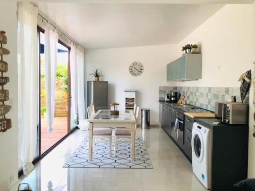 - une cuisine avec une table blanche et un évier dans l'établissement LE MAS DES oliviers, à La Celle-sous-Gouzon