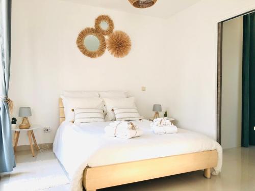 une chambre avec un lit blanc avec deux serviettes dessus dans l'établissement LE MAS DES oliviers, à La Celle-sous-Gouzon