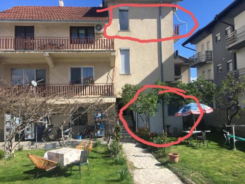 a building with a red ribbon in front of a yard at Rooms Struga in Struga