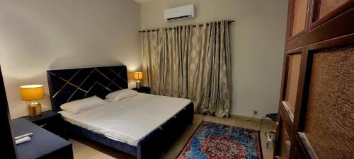 a bedroom with a bed and a large window at UrbanNook in Rawalpindi