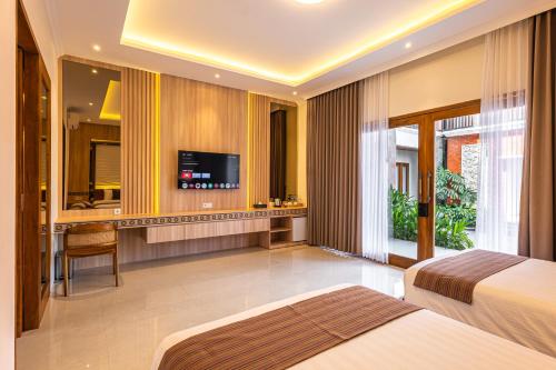 a hotel room with two beds and a flat screen tv at Kalynda Boutique Villa in Kejayan