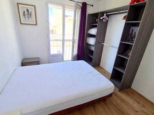 une chambre avec un lit blanc et un placard dans l'établissement Appartement T3 au calme à 600 m des plages avec Parking, Wi-Fi et équipements modernes - FR-1-316-331, à Six-Fours-les-Plages